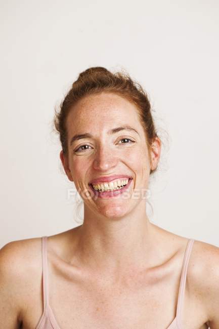 Femme rousse souriant et regardant à la caméra, plan studio . — Photo de stock