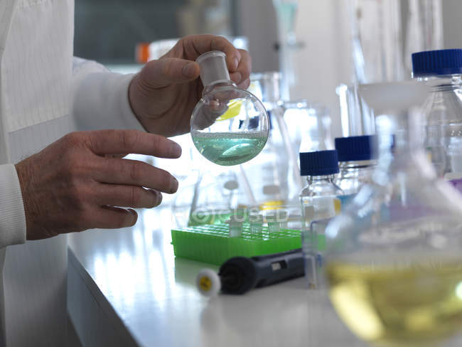 Wissenschaftler bereitet chemische Flüssigkeit in Laborkolben vor. — Stockfoto