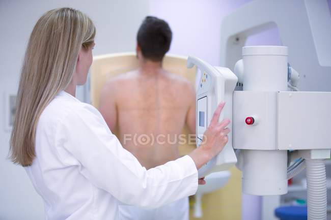 Жінка-лікар вивчає чоловічі груди з рентгенівським випромінюванням . — стокове фото