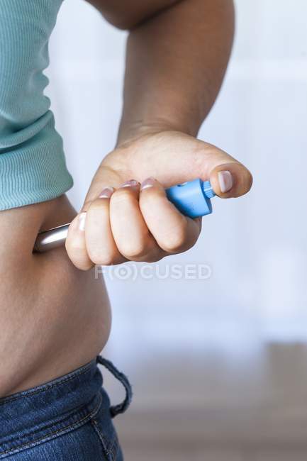 Close-up of woman making self-injection in belly. — Stock Photo