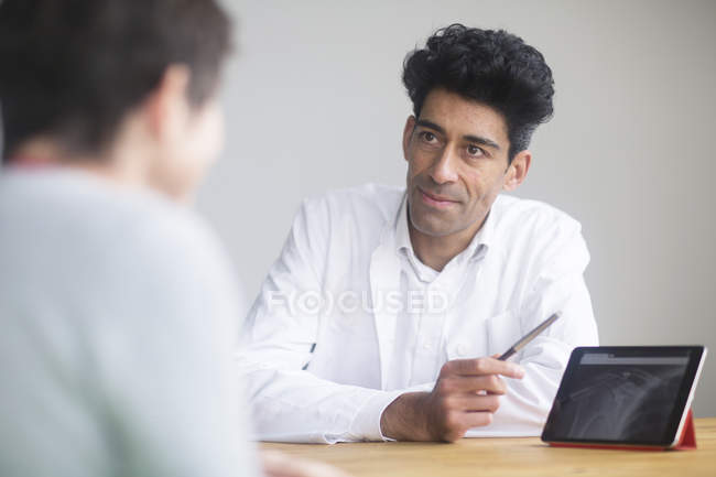 Medico discutendo raggi X su tablet digitale con il paziente . — Foto stock