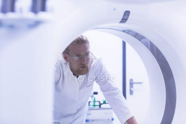 Radiologiste masculin regardant à travers le scanner CT . — Photo de stock