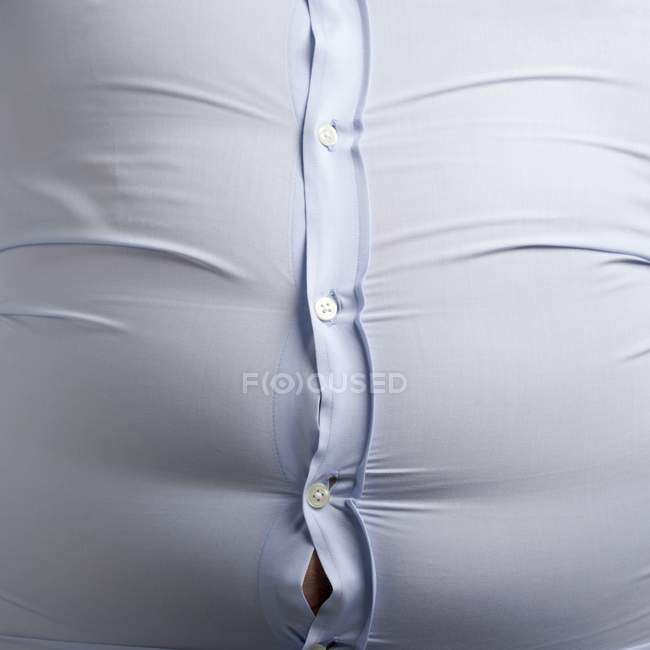 Übergewichtiger Mann trägt blaues Hemd mit prall gefüllten Knöpfen. — Stockfoto