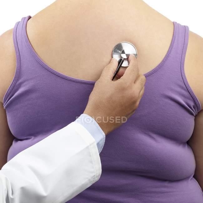 Vista ritagliata della mano del medico utilizzando lo stetoscopio per l'esame della donna in sovrappeso . — Foto stock