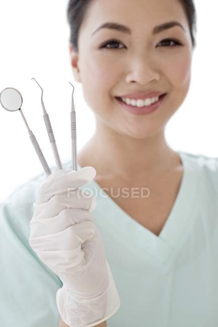 Жінка-стоматолог тримає стоматологічні інструменти, портрет . — стокове фото