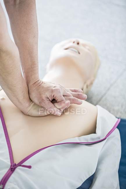 Doctor practicing chest compression on cardiopulmonary resuscitation training dummy. — Stock Photo