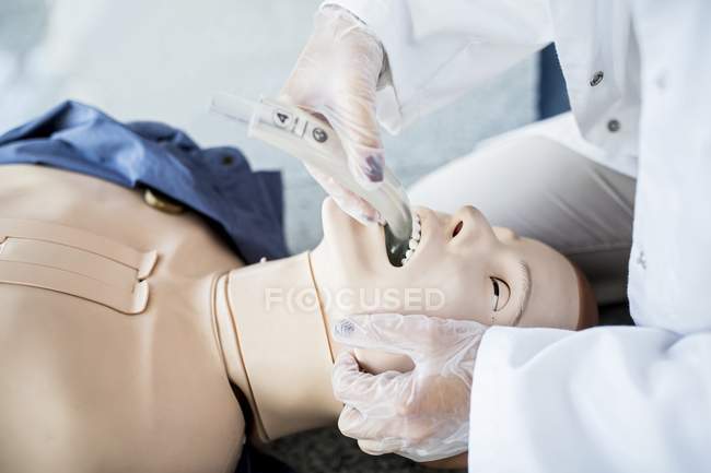 Médecin pratiquant l'intubation trachéale sur mannequin d'entraînement . — Photo de stock