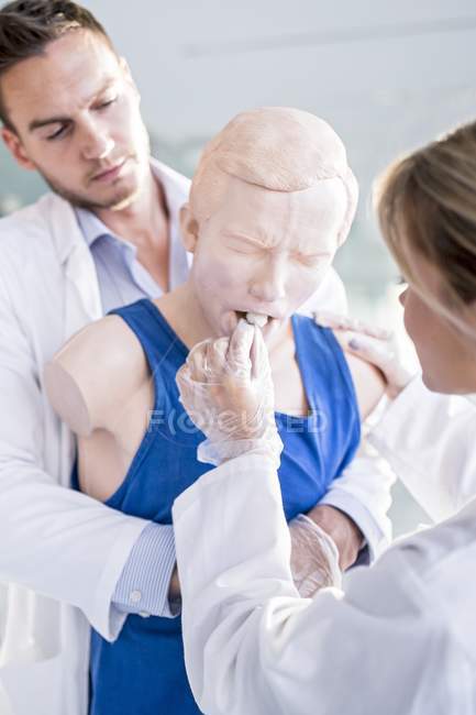 Medical students practicing Heimlich manoeuvre on training dummy. — Stock Photo