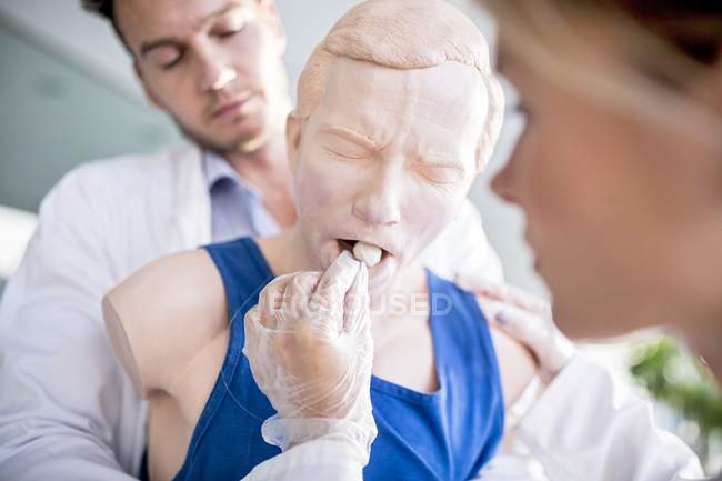 Doctors practicing Heimlich manoeuvre on training dummy. — Stock Photo