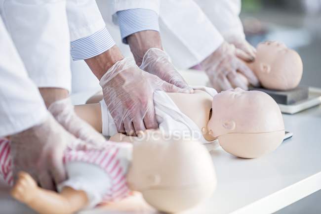 Лікарі практикуючих ущільнення в грудях на малюкової навчання чайників. — стокове фото
