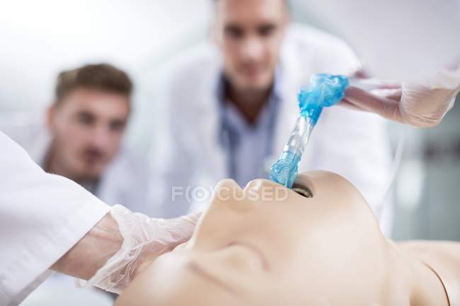 Médecins masculins pratiquant l'intubation trachéale sur mannequin d'entraînement . — Photo de stock