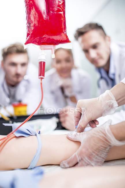 Medizinstudenten üben das Einführen einer intravenösen Linie an einer Trainingspuppe. — Stockfoto