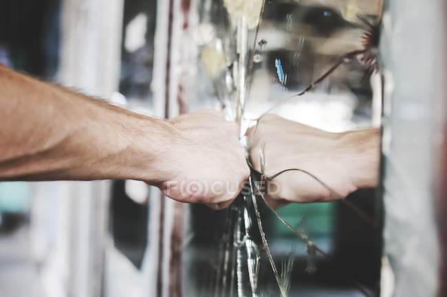 Cropped view of frustrated and aggravated man punching mirror. — Stock Photo