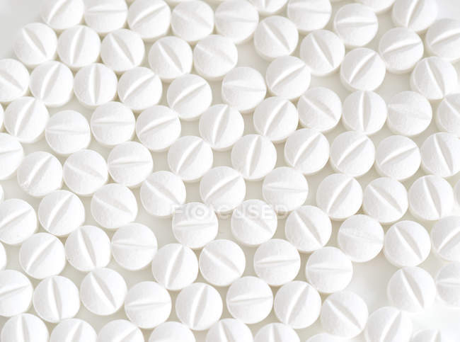 Белые таблетки на белом фоне, полный кадр . — стоковое фото