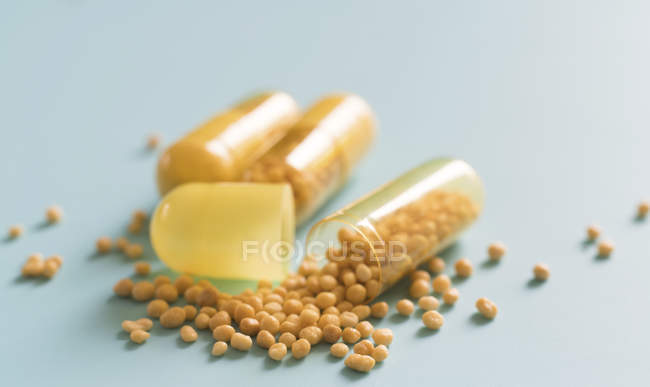 Pills pouring from dietary supplement capsules. — Stock Photo