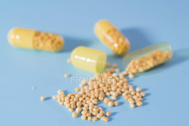 Pastillas que se vierten de cápsulas de suplementos dietéticos . - foto de stock
