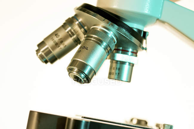 Close-up of light microscope lenses on white background. — Stock Photo