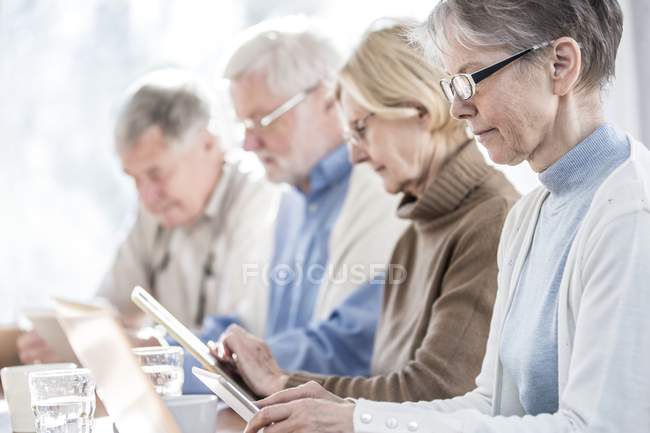Senior adults in care home using tablet computers. — Stock Photo