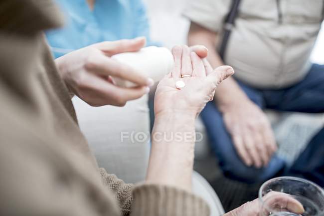 Senior mulher recebendo medicação de prescrição em casa de cuidados, close-up . — Fotografia de Stock