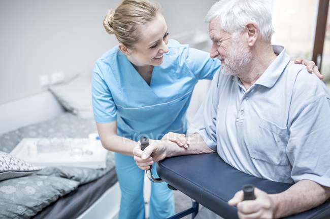Старший мужчина использует роллатор с медсестрой-ассистенткой . — стоковое фото