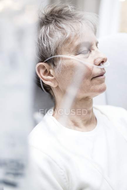 Femme âgée avec canule nasale avec les yeux fermés, gros plan . — Photo de stock