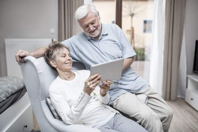 Seniorenpaar schaut im Krankenhauszimmer auf digitales Tablet. — Stockfoto
