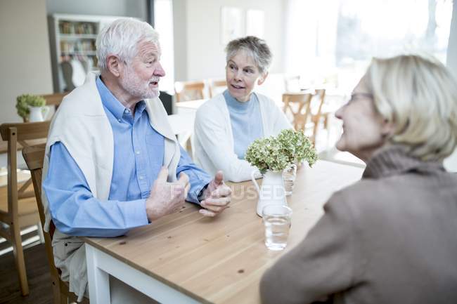 Homme âgé parlant à des amies dans une maison de soins . — Photo de stock