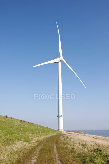 Rural scene of wind turbine against blue sky. — Stock Photo
