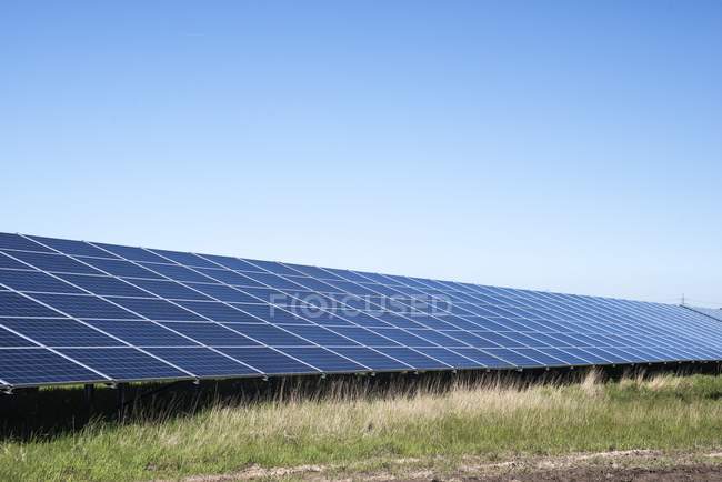 Fila de painéis solares na fazenda solar em North Wales, Reino Unido . — Fotografia de Stock