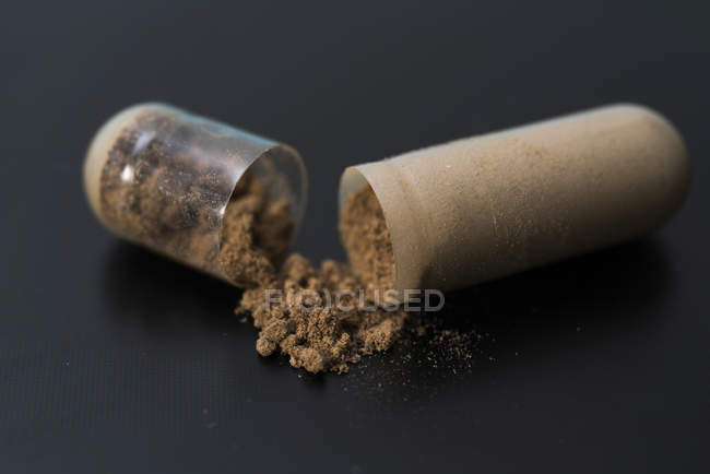 Open supplement capsules on table, close-up. — Stock Photo