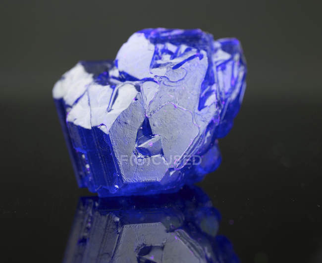 Blauer mineralischer Edelstein auf Spiegeloberfläche. — Stockfoto