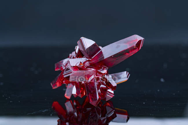 Cristalli minerali rossi su sfondo grigio . — Foto stock