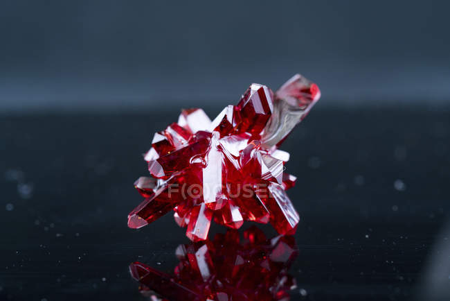 Красные минеральные кристаллы на сером фоне . — стоковое фото