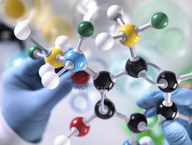 Chercheur concevant une formule chimique avec modèle moléculaire . — Photo de stock