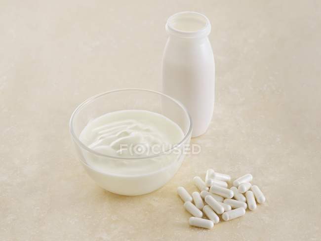 Pilules probiotiques et yaourt, nature morte . — Photo de stock