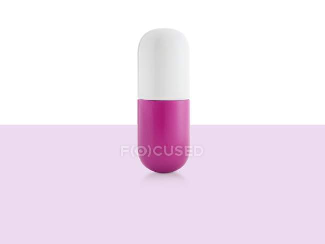 Pink and white capsule, studio shot. — Stock Photo