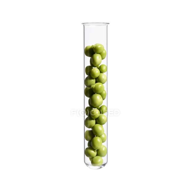 Grüne Erbsen im Reagenzglas, Studioaufnahme. — Stockfoto