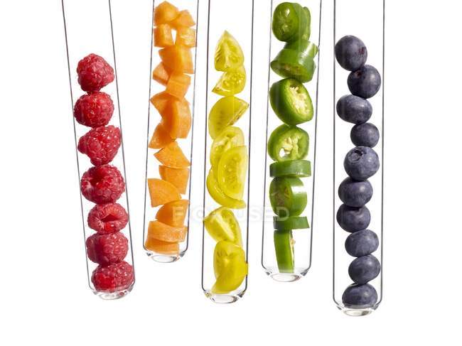 Frutas y verduras coloridas en tubos de ensayo, toma de estudio . - foto de stock