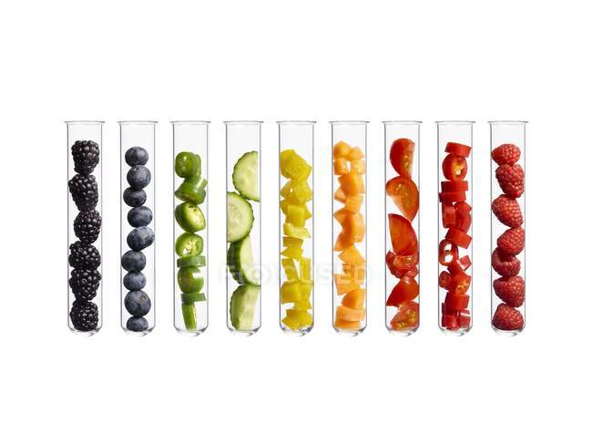 Frutas e legumes coloridos em tubos de ensaio, tiro estúdio . — Fotografia de Stock