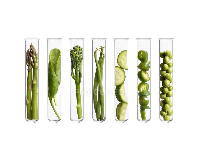 Green vegetables in test tubes, studio shot. — Stock Photo