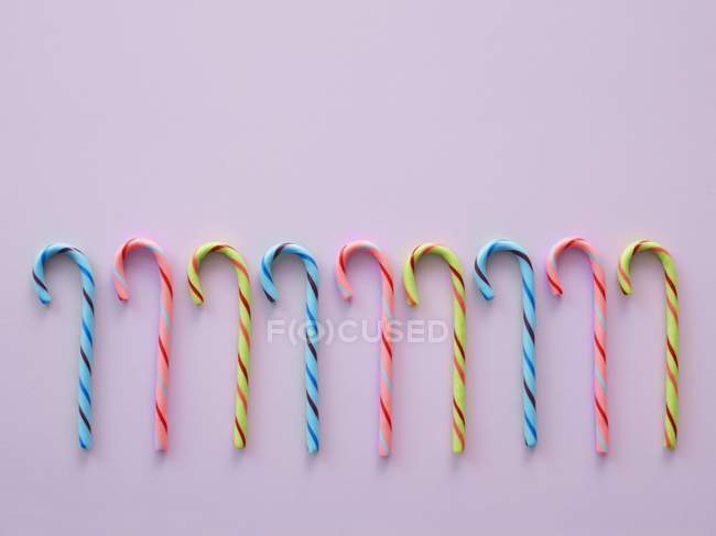 Caramelos de colores brillantes sobre fondo lila . - foto de stock