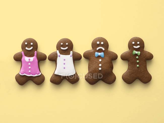 Obese and healthy gingerbread men on yellow background. — Stock Photo