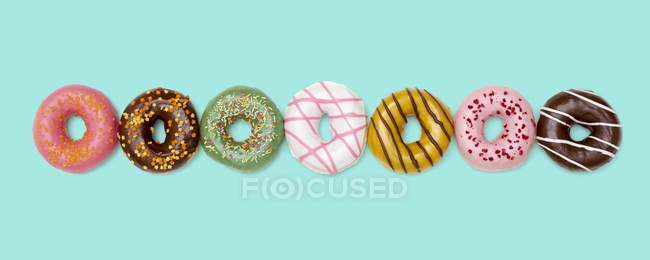 Bunte Donuts in einer Reihe, Studioaufnahme. — Stockfoto