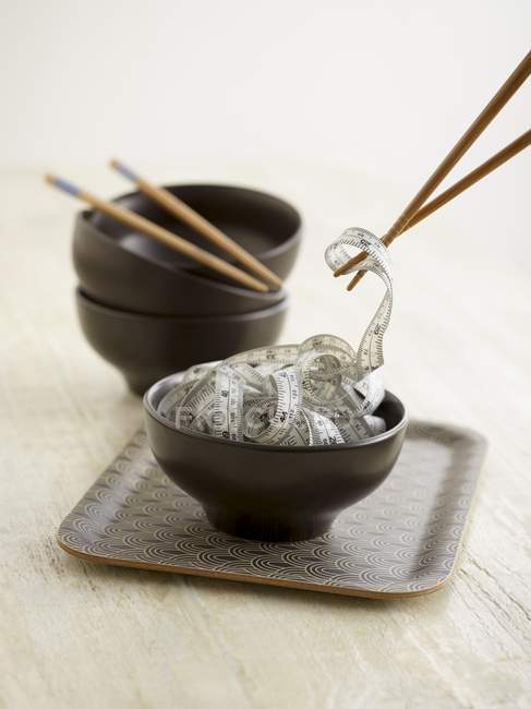 Палочки для еды, берущие рулетку из китайской миски . — стоковое фото