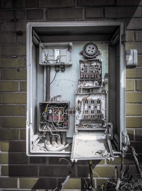 Caja de fusibles en desuso en la pared del edificio industrial abandonado . - foto de stock
