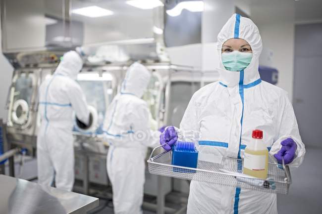 Technicien transportant l'équipement et la solution dans un laboratoire stérile . — Photo de stock