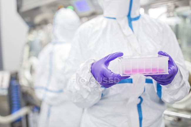 Vue en culture d'un technicien de laboratoire portant une trousse d'analyse cellulaire dans un laboratoire de bio-ingénierie
. — Photo de stock