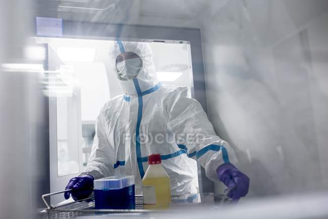 Techniker sammelt Geräte aus Transferluke im sterilen Labor. — Stockfoto