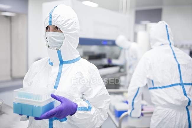 Técnico que sostiene muestras de células en laboratorio de bioingeniería . - foto de stock
