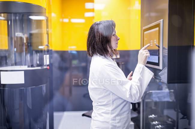 Técnico feminino máquina de programação em laboratório de nanofibra . — Fotografia de Stock